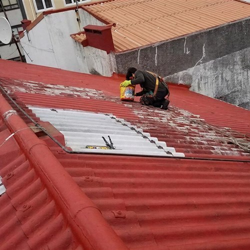 Operario de Tejados y Fachadas Humberto impermeabilizando una cubierta de uralita en A Coruña
